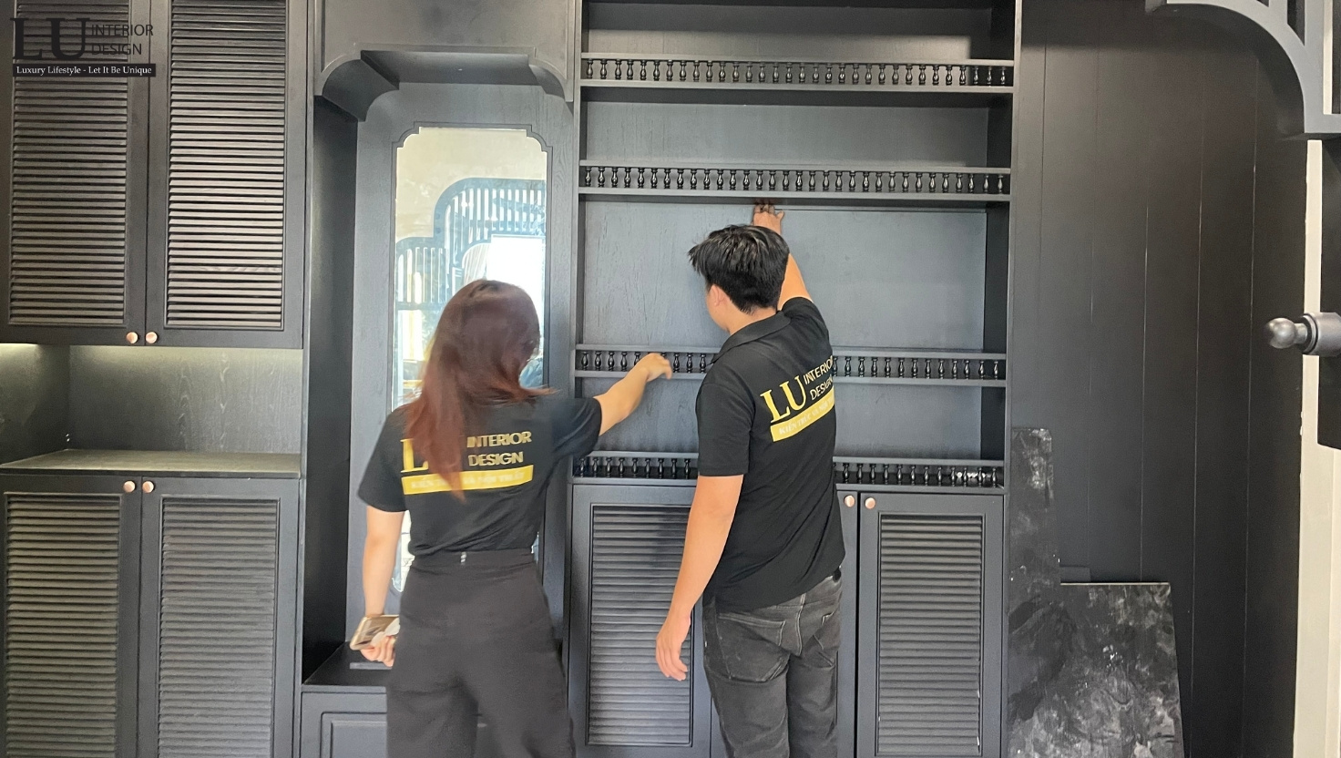 Đội ngũ LU Design đang thi công và kiểm tra chi tiết tủ kệ nội thất màu đen trong căn hộ